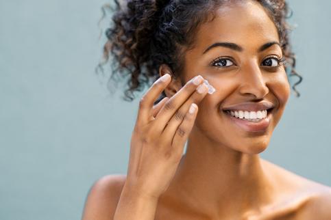 woman applying moisturizing lotion on face